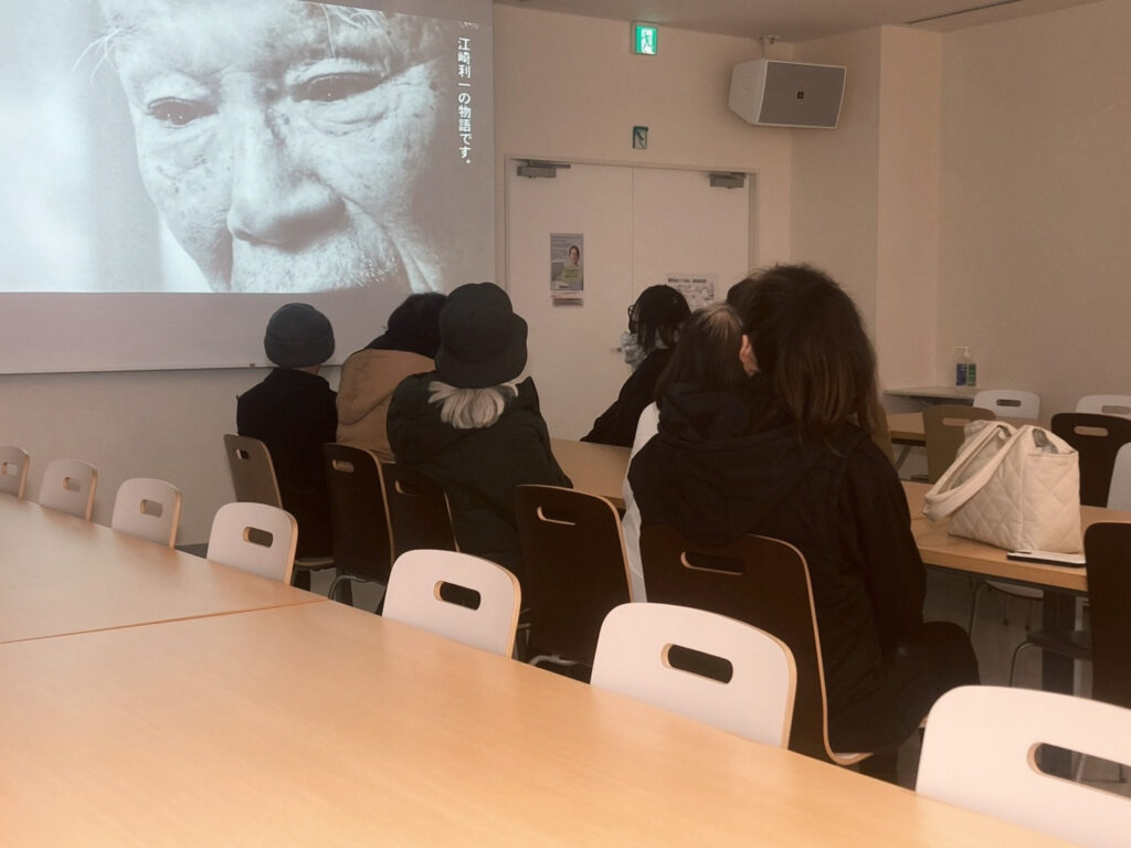 グリコピア見学でメンバーが映像を見ている様子